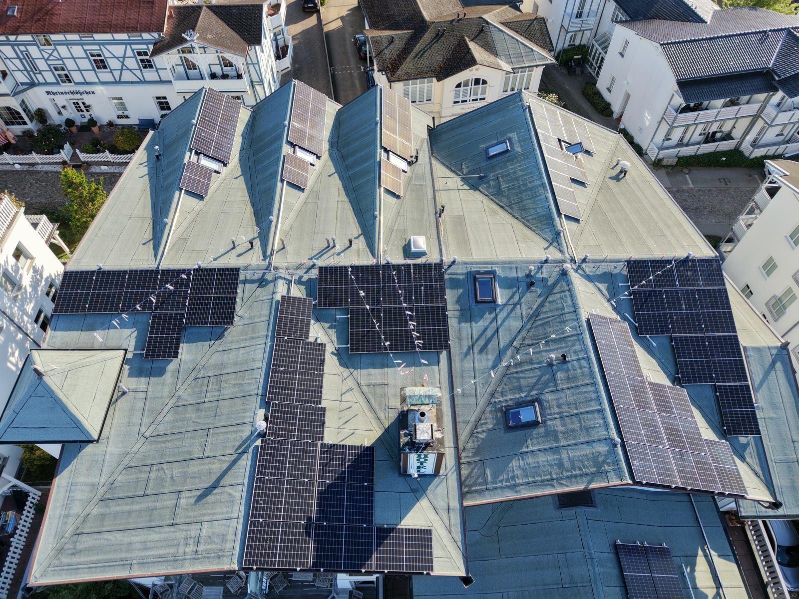 Hoteldach in Göhren mit Solarmodulen in der Morgensonne, Luftaufnahme