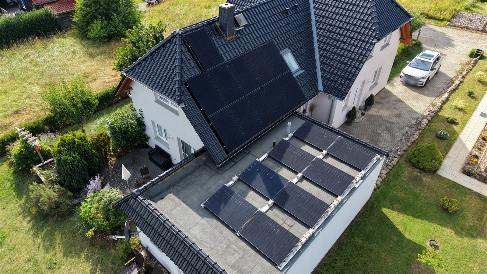 Photovoltaikanlage auf Schrägdach und Flachdach eines Hauses auf Rügen aus der Luft